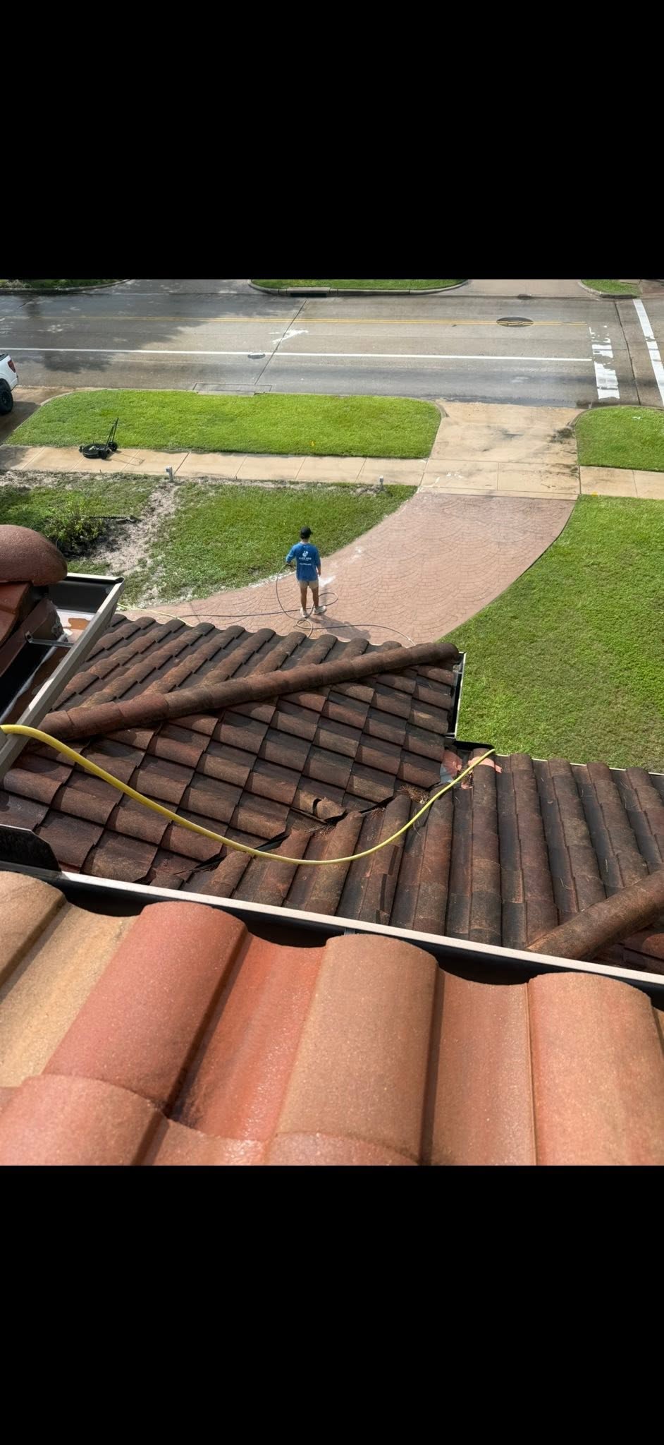 Clean Kings crew member soft washing a tile roof